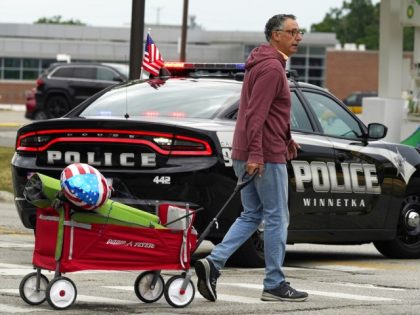 A man carries his belongings after a mass shooting at the Highland Park Fourth of July parade in downtown Highland Park, Ill., a Chicago suburb on Monday, July 4, 2022. (AP Photo/Nam Y. Huh)