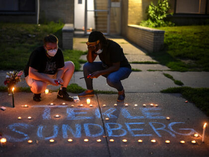 MINNEAPOLIS, MN. - JULY 2022: Marcia Howard, activist and George Floyd Square caretaker, right, takes a moment as she lights candles during a vigil for 20-year old Andrew Tekle Sundberg Thursday, July 14, 2022 outside the apartment building where he was killed by Minneapolis Police in Minneapolis, Minn.. Minneapolis police …