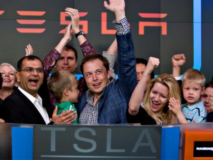 Elon Musk, chairman and chief executive officer of Tesla Motors, center, participates in the opening bell ceremony at the Nasdaq Marketsite with his twin boys Griffin, green shirt at center, and Xavier, right in blue shirt, and his fiancee Talulah Riley, second from right, in New York, U.S., on Tuesday, …
