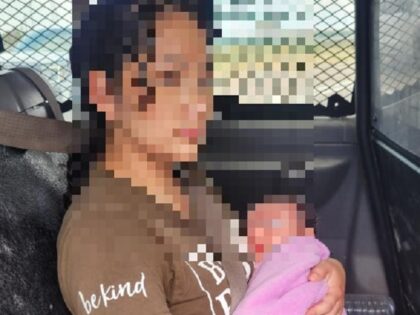 A migrant mother holds her newborn baby after a police pursuit in Brooks County, Texas. (U.S. Border Patrol/Rio Grande Valley Sector)