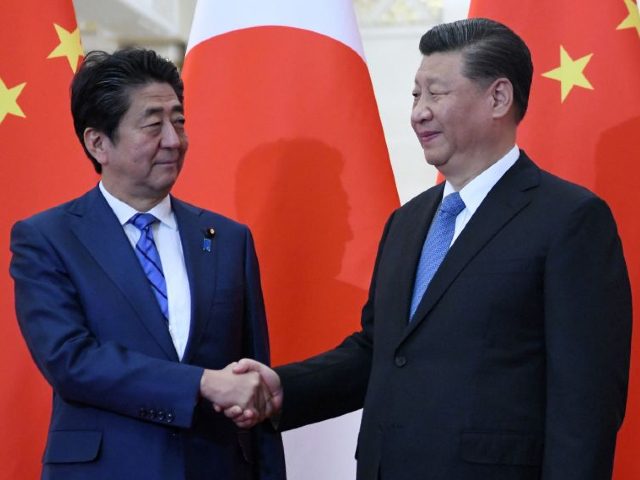 Japan's Prime Minister Shinzo Abe (L) shakes hand with China's President Xi Jinping at the Great Hall of the People in Beijing on December 23, 2019. (Photo by Noel CELIS / POOL / AFP) (Photo by NOEL CELIS/POOL/AFP via Getty Images)