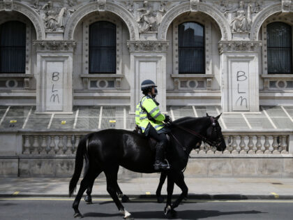 TOPSHOT - Mounted police pass graffiti written on the Foreign and Commonwealth Office in c