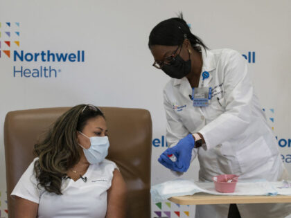 Michelle Chester, doctor of nursing practice (DNP) and director of employee health services at Northwell Health Inc., prepares to administer the Moderna Inc. Covid-19 vaccine to Arlene Ramirez, registered nurse (RN) and director of patient care at Long Island Jewish Valley Stream, left, at the hospital in Valley Stream, New …