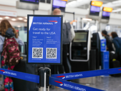 A sign with QR codes for preparations for traveling to the United States in Terminal 5 at London Heathrow Airport in London, U.K., on Monday, Nov. 8, 2021. The U.S. is lifting entry restrictions for more than 30 countries, allowing fully vaccinated travelers to fly from places including Europe, China …