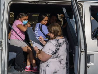 Karen Quevedo, program advocate for Colores United, takes roll of families departing to th