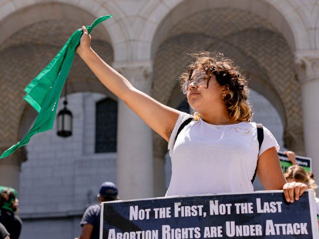 Los Angeles, CA - July 06: Natalie Monzon holds a Rise Up 4 Abortion Rights bandana outsid