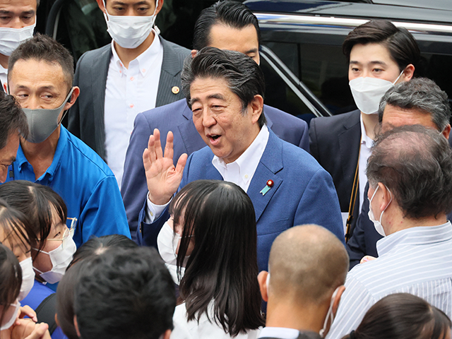 This picture taken on July 6, 2022 shows former Japanese Prime Minister Shinzo Abe (C) mee