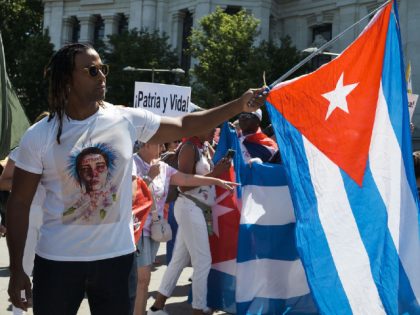 MADRID, SPAIN - 2022/07/10: Singer Yotuel Romero holds a Cuban flag during the demonstration to demand the end of the dictatorship and the freedom of political prisoners in Cuba held on the Paseo de Prado in Madrid. The march is organised by #SOSCUBA to commemorate July 11 and demand the …