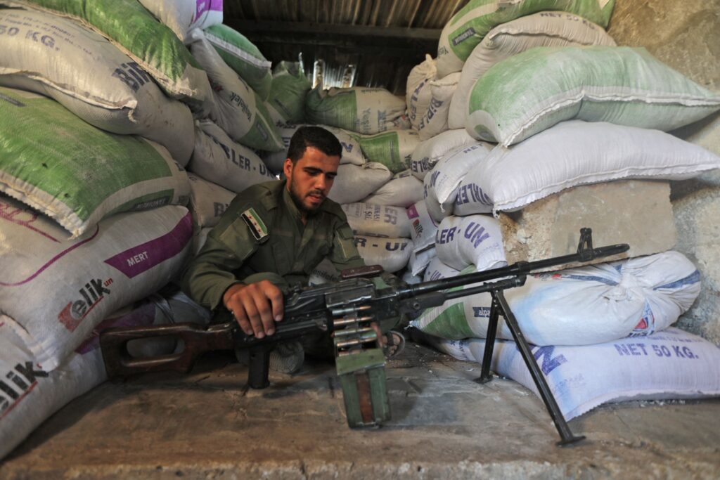A Turkey-backed fighter mans a military position in the Syrian area of Jibrin in Aleppo's eastern countryside, across from the Kurdish-controlled area of Tal Rifaat, on July 19, 2022. - Turkey has launched waves of attacks on Syria since 2016 targeting Kurdish groups as well as Islamic State group jihadists and Assad loyalists, and is threatening with a new offensive against Tal Rifaat and Manbij, two towns under the control of the People's Protection Units (YPG), a Kurdish militia accused by Turkey of being affiliated with the Kurdistan Workers' Party (PKK), classified as terrorist by Ankara. (Photo by Bakr ALKASEM / AFP) (Photo by BAKR ALKASEM/AFP via Getty Images)