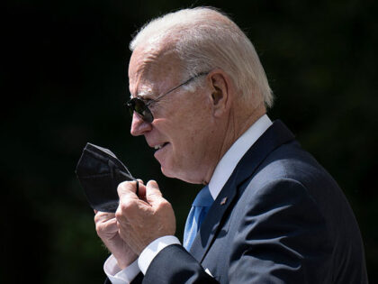 US President Joe Biden removes his protective mask while arriving to deliver remarks in the Rose Garden of the White House in Washington, DC, on July 27, 2022. - Biden has had two negative Covid-19 tests and no longer needs to isolate after recovering from infection, his White House Doctor …