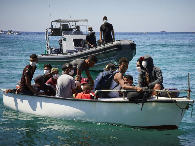 LAMPEDUSA, ITALY - AUGUST 28: Migrants from Tunisia dock their boat at a port on August 28, 2020 in Lampedusa, Italy. Lampedusa, which is at the forefront the EU's struggle to deal with migrants crossing the Mediterranean from the coasts of Africa, has reportedly run out of room to quarantine …