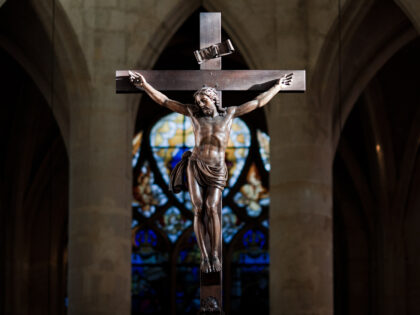 Statue of Jesus Christ on Cross enlightened by sunlight in Saint Étienne du Mont Basilica, Paris.