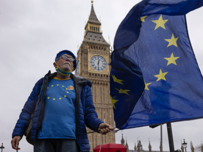 LONDON, ENGLAND - MAY 11: A pro Europe Brexit protester waves an EU flag in Parliament Square on May 11, 2022 in London, England. British Prime Minister Boris Johnson has renewed warnings that he would be prepared to override parts of the Northern Ireland Protocol, rather than jeopardising the Good …