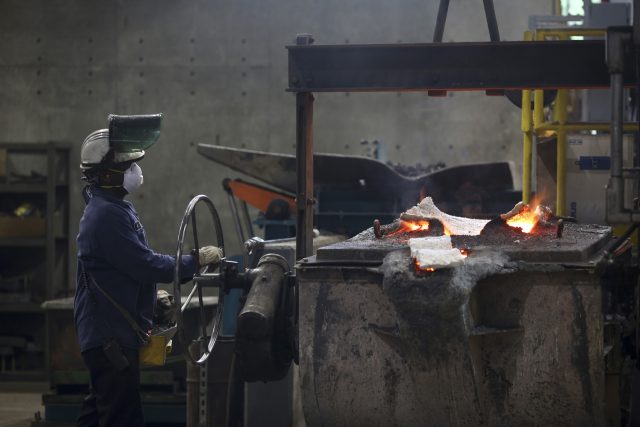 A worker manipulates a cask of molten iron before pouring it into molds to make cast iron cookware at the Lodge Manufacturing Co. factory in South Pittsburg, Tennessee, U.S., on Thursday, May 21, 2015. The U.S. Census Bureau is scheduled to release durable goods figures on May 26. Photographer: Luke …