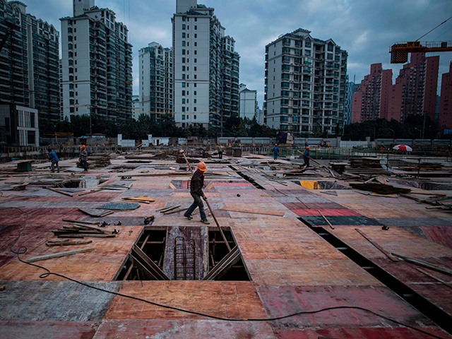 A man works at a construction site of a residential skyscraper in Shanghai on November 29, 2016. - Chinese household debt has risen at an "alarming" pace as property values have soared, analysts say, raising the risk that a real estate downturn could send shockwaves through the world's second largest …