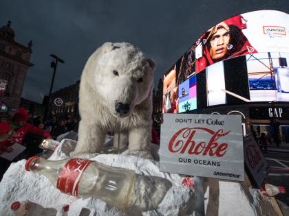 LONDON, ENGLAND - DECEMBER 05: Greenpeace activists hold a demonstration in front of the Piccadilly Circus electronic billboard as part of a global campaign to get Coca Cola to reduce their plastic footprint on December 5, 2017 in London, England. Unveiling a life size polar bear puppet on an Arctic …