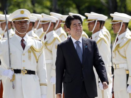 FILE - Then Japanese Prime Minister Shinzo Abe, center, reviews an honor guard in a ceremony prior to his meeting with high-ranked officers of the Japan Self-Defense Forces at the Defense Ministry in Tokyo on Sept. 12, 2013. Former Japanese Prime Minister Abe, a divisive arch-conservative and one of his …