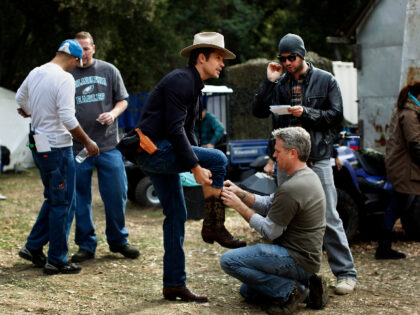 Clendenin, Jay –– B58898832Z.1 GREEN VALLEY, CA ––DECEMBER 03, 2010–– Actor Timothy Olyphant, center in cowboy hat, is prepared for his michrophone before shooting begins on the "Church of the Two–Stroke Jesus" set for a scene in FX's "Justified," in the Green Valley area, north of Los Angeles, Dec. 3, …