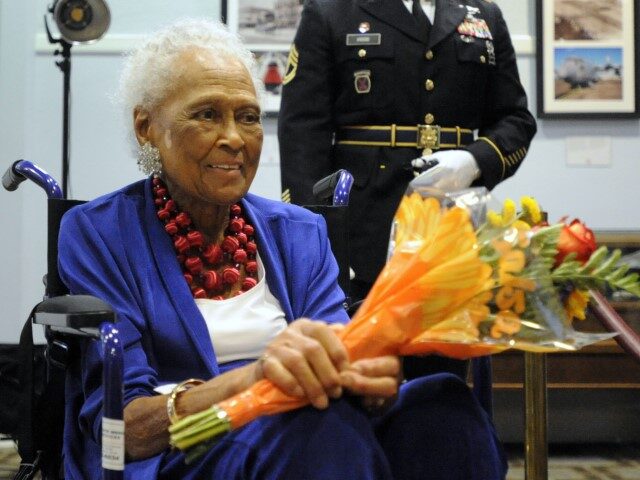 Romay Davis, 102, holds flowers after a ceremony honoring her service in World War II duri