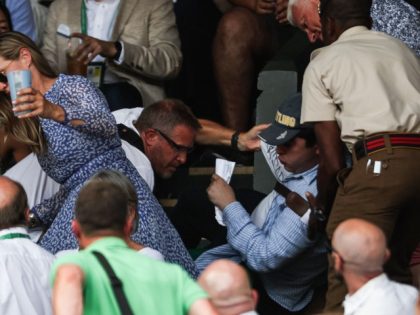 Security personnel and spectators remove a protester from the stands during the men's singles final tennis match between Serbia's Novak Djokovic and Australia's Nick Kyrgios on the fourteenth day of the 2022 Wimbledon Championships at the All England Tennis Club in Wimbledon, southwest London, on July 10, 2022. (ADRIAN DENNIS/AFP …