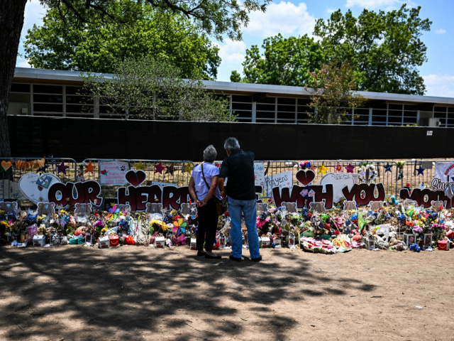 People visit a makeshift memorial to the victims of a shooting at Robb Elementary School in Uvalde, Texas, on June 30, 2022. - Nineteen young children and two teachers were killed when a teenage gunman went on a rampage at Robb Elementary on May 24 in America's worst school shooting …