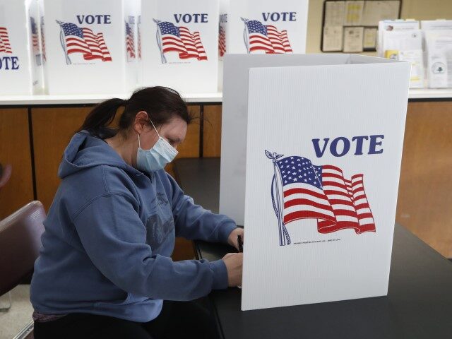 In this May 5, 2020 file photo, Angela Beauchamp fills out an absentee ballot at City Hall in Garden City, Mich. This year, Republicans across the country have zeroed in on mail voting and enacted new limits on a process that exploded in popularity during the pandemic. (Paul Sancya/AP)