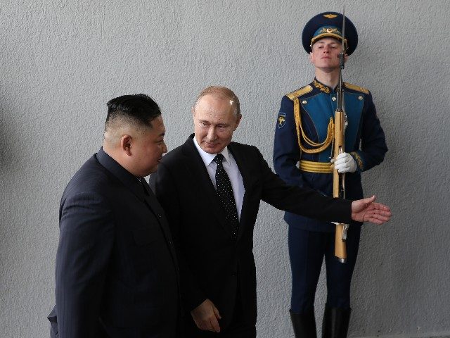 Russian President Vladimir Putin (R) greets North Korean Leader Kim Jong-un (L) before a m