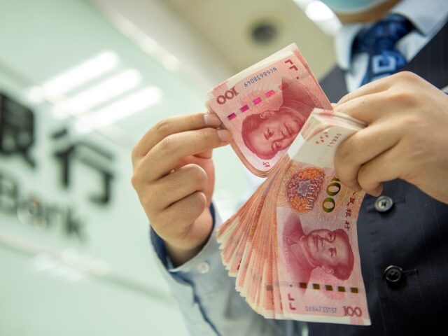 HAI'AN, CHINA - MAY 15 2022: A clerk counts renminbi banknotes at a bank outlet in Hai'an in east China's Jiangsu province Sunday, May 15, 2022. The International Monetary Fund (IMF) has decided to increase the weight of the Renminbi in the basket from 10.92% to 12.28% in the recent …