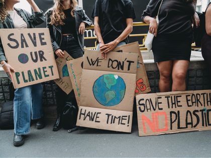 People are holding banner signs while they are going to a demonstration against climate change - stock photo