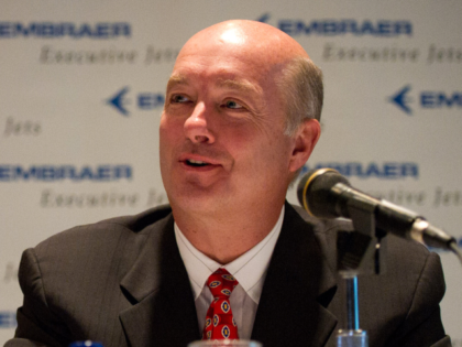 David Sokol, chairman and chief executive officer of NetJets Inc., right, speaks while Fre