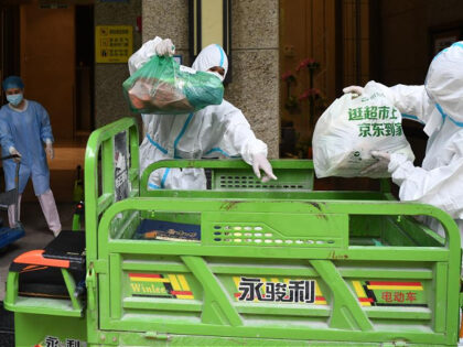 Staff members of a property management company deliver online shopping goods ordered by residents under home quarantine at a residential area at Liwan District of Guangzhou, capital of south China's Guangdong Province, June 2, 2021. Guangzhou has tightened anti-epidemic measures in parts of the city to curb the recent COVID-19 …