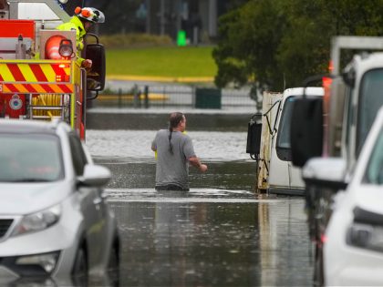 A man walks through flood waters back to his home from a fire truck at Windsor on the outskirts of Sydney, Australia, Tuesday, July 5, 2022. Hundreds of homes have been inundated in and around Australia’s largest city in a flood emergency that was threatening 50,000 people, officials said on …