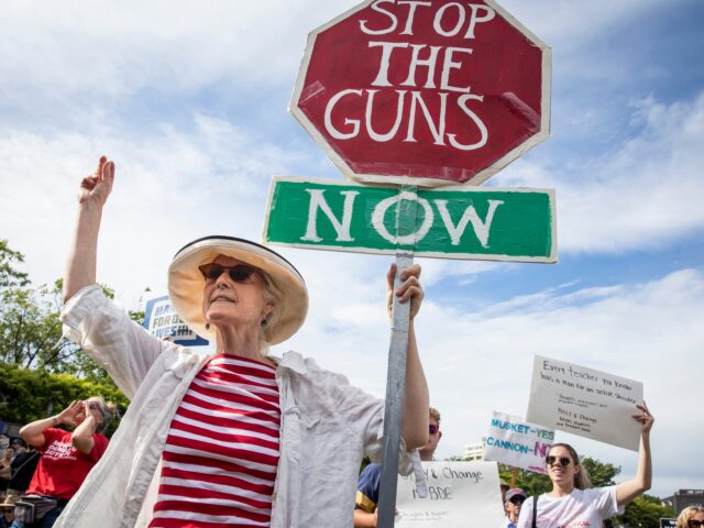 Boston - June 11: Eileen Ryan holds a sign that reads Stop The Guns Now while attending a