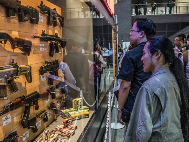 Attendees look at a display of toy guns during a media preview day of the Tokyo Game Show