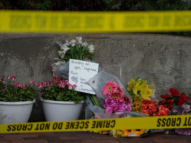 Flowers are left for victims of the 4th of July mass shooting in downtown Highland Park, Illinois on July 5, 2022. - The suspected gunman who opened fire on a July 4 parade in a wealthy Chicago suburb planned the attack for weeks and wore women's clothing to aid his …