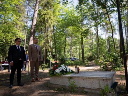 Karol Nawrocki, right, head of the Institute of National Remembrance (IPN), stands in front of a grave as he meets the media near Działdowo, Poland, Wednesday, July 13, 2022. Special investigators in Poland say they have found mass graves containing the ashes of at least 8,000 Poles slain by Nazi …