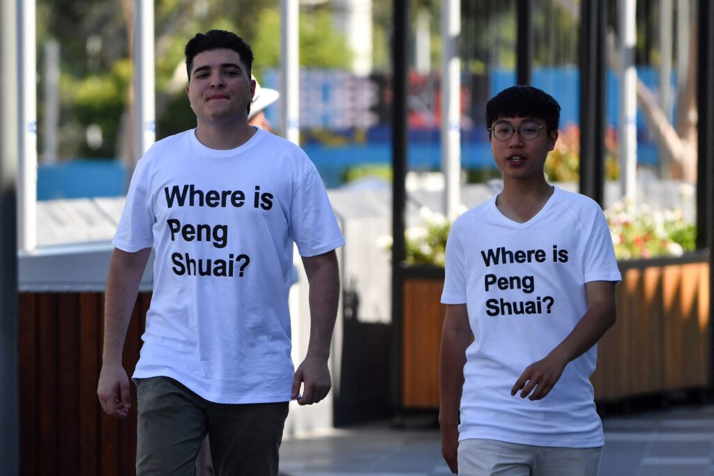 Australian human rights campaigner Drew Pavlou (L) is pictured wearing a "Where is Peng Shuai?" T-shirt, referring to the former doubles world number one from China, on the grounds outside one of the venues on day nine of the Australian Open tennis tournament in Melbourne on January 25, 2022. - -- IMAGE RESTRICTED TO EDITORIAL USE - STRICTLY NO COMMERCIAL USE -- (Photo by Paul Crock / AFP) / -- IMAGE RESTRICTED TO EDITORIAL USE - STRICTLY NO COMMERCIAL USE -- (Photo by PAUL CROCK/AFP via Getty Images)