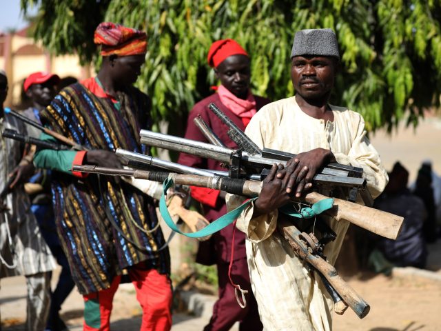 Members of the Yansakai vigilante group bring their weapons into the Zamfara State Governm