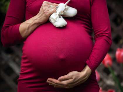 Pregnant Woman Holding baby's shoes (Andre Furtado/Pexels)
