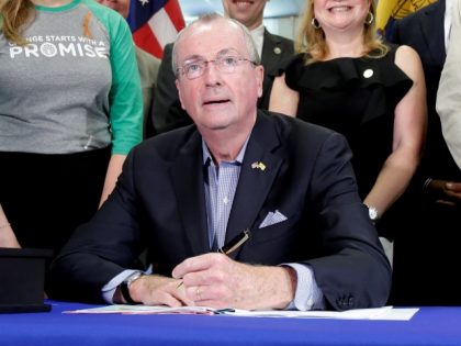 New Jersey Gov. Phil Murphy, center, signs a gun control bill during a ceremony in Berkeley Heights, N.J., Tuesday, July 16, 2019. Murphy has signed a measure aimed at making so-called smart guns available in the state. He also signed three other measures aimed at reining in gun violence. (AP …