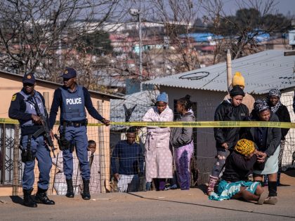 A relative of one of the 14 victims shot dead in a tavern in Soweto reacts next to the crime scene in Soweto on July 10, 2022. - Fourteen people were killed during a shootout in a bar in Soweto police said on July 10, 2022. Police lieutenant Elias Mawela …