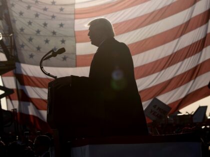 US President Donald Trump is seen in silhouette against a US flag as he speaks during a "Great American Comeback" rally at Bemidji Regional Airport in Bemidji, Minnesota, on September 18, 2020. (Photo by Brendan Smialowski / AFP) (Photo by BRENDAN SMIALOWSKI/AFP via Getty Images)