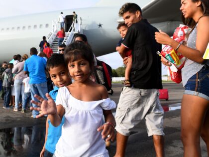 Venezuelan refugees board a Brazilian Air Force plane, heading to Manaus and Sao Paulo, at Boa Vista airport, Roraima state, north of Brazil on May 4, 2018. - The Brazilian government initiated a program of internalisation of refugees who arrive in Boa Vista through the border with Venezuela. In the …