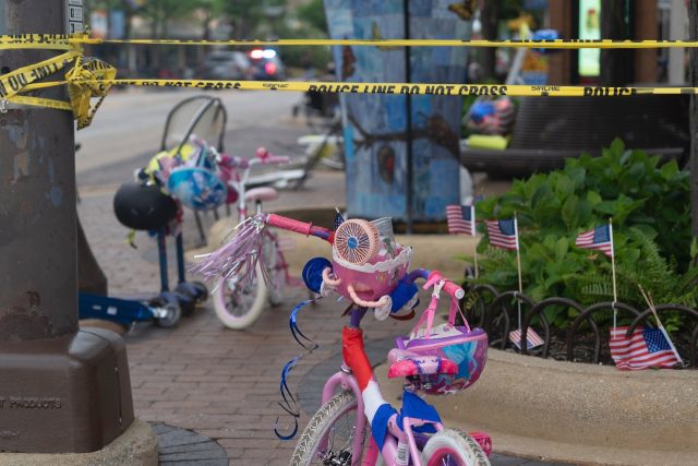 Police tape is seen around the scene of the July 4 parade shooting, littered with children's bicycles and baby strollers, in Highland Park, Illinois