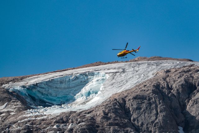 A rescue helicopter flies over the partially collapsed glacier on Marmolada, the highest m