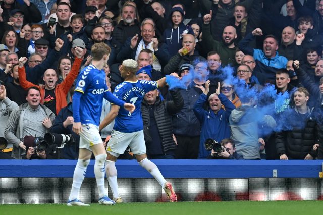 Richarlison (C) throws a smoke bomb off the pitch