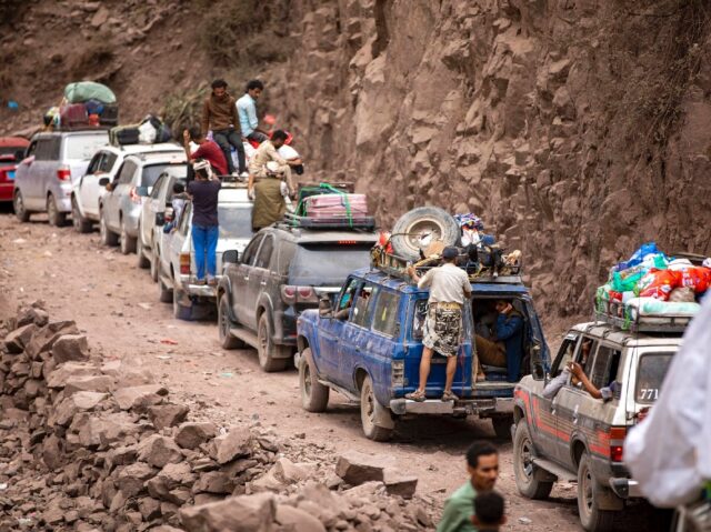 Traffic on a heavily damaged narrow road that serves as a lifeline between the Yemeni city