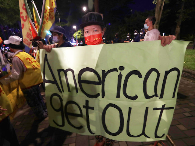 A protester holds a banner during a protest against the visit of United States House Speaker Nancy Pelosi, outside a hotel in Taipei, Taiwan, Tuesday, Aug 2, 2022. Pelosi arrived in Taiwan on Tuesday on a visit that could significantly escalate tensions with Beijing, which claims the self-ruled island as its own territory. (AP Photo/Chiang Ying-ying)