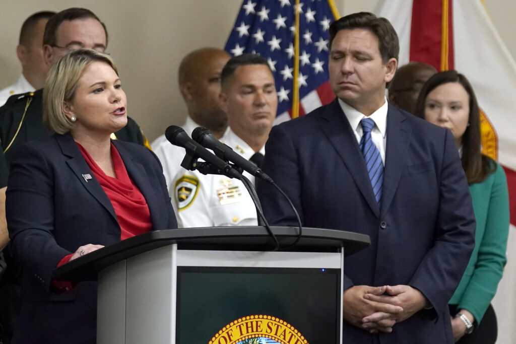 Judge Susan Lopez, left, acting Florida State Attorney for the 13th Judicial Circuit, speaks during a news conference with Florida Gov. Ron DeSantis, second from right, and Florida Attorney General Ashley Moody, right, Thursday, Aug. 4, 2022, in Tampa, Fla. DeSantis announced that he was suspending State Attorney Andrew Warren, of the 13th Judicial Circuit, due to "neglect of duty." (AP Photo/Chris O'Meara)