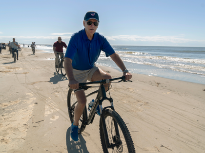 President Joe Biden rides a bicycle along the beach at Kiawah Island, S.C., Sunday, Aug. 14, 2022. Biden is in Kiawah Island with his family on vacation. (AP Photo/Manuel Balce Ceneta)